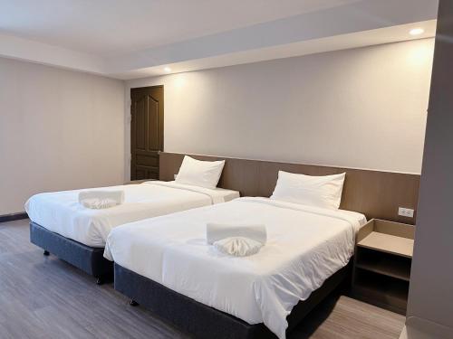 a hotel room with two beds with white sheets at Miloft Suvarnabhumi Airport Hotel in Bangkok
