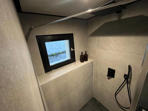 une salle de bain avec une télévision sur un mur dans l'établissement Le Chevran, à Cluses