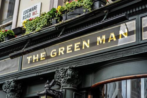 a green man sign on the side of a building at PubLove @ The Green man, Paddington in London