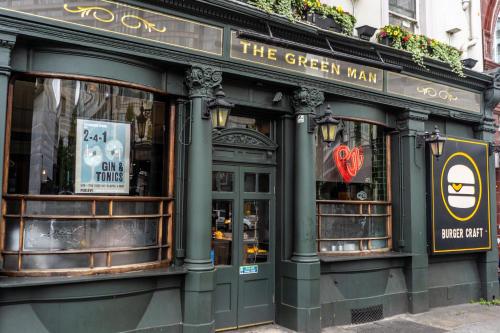 a green building with the green man on the street at PubLove @ The Green man, Paddington in London