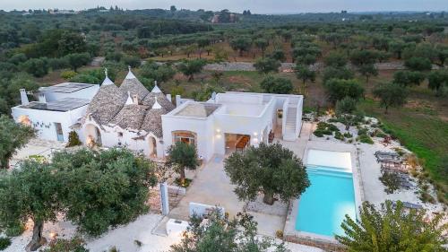 eine Luftaufnahme eines Hauses mit Swimmingpool in der Unterkunft TD Marlù Luxury Trulli Experience with Stunning Pool in Castellana Grotte