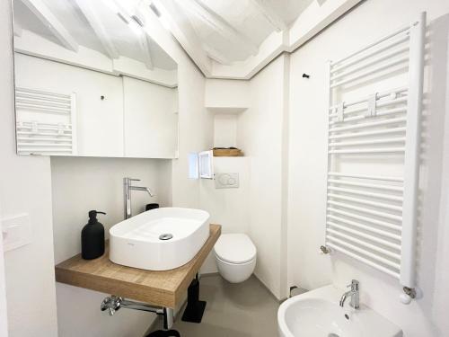 un bagno bianco con lavandino e WC di Il Nido vicino Piazza del Campo a Siena