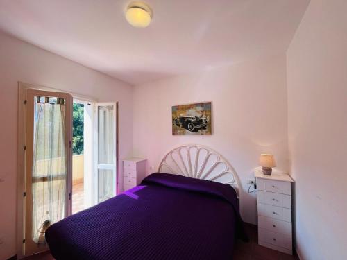 a bedroom with a purple bed and a window at Casa Solana al Cavo - Elba Affitti in Cavo