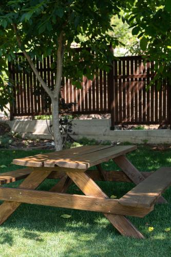 a wooden picnic table sitting in the grass next to a tree at Divine Forest in Litochoro