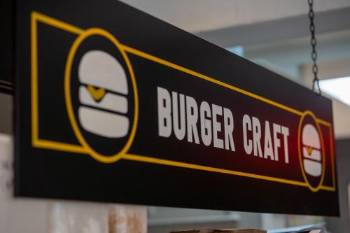 a sign for a burger grill hanging from a chain at PubLove @ The Crown, Battersea in London
