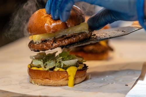 a person is cutting a sandwich with a knife at PubLove @ The Crown, Battersea in London