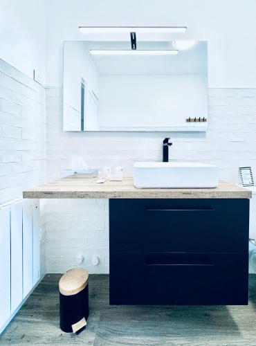 a bathroom with a sink and a counter with a mirror at Hôtel Jules in Le Touquet-Paris-Plage