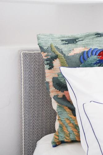 a pillow on a bed next to a painting at Cortijo Genesis in Gaucín