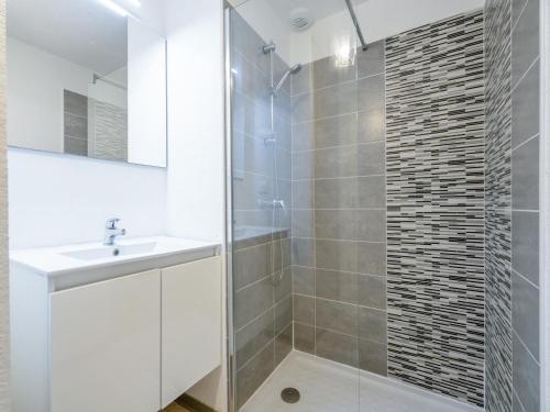 une salle de bain blanche avec un lavabo et une douche dans l'établissement La Dune 22 - Villa 2P4, à Sérignan