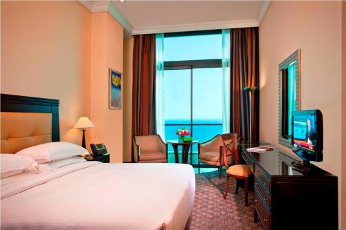 a hotel room with a bed and a television at Raouche Arjaan by Rotana in Beirut