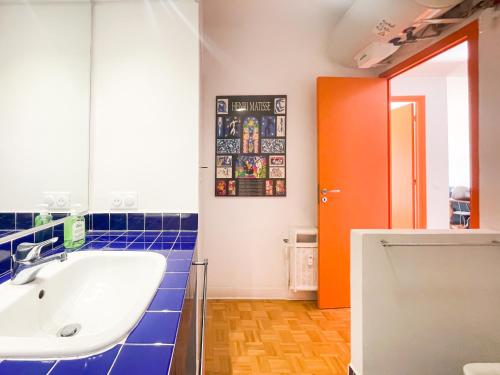 La salle de bains est pourvue d'un lavabo blanc et d'une porte orange. dans l'établissement Paradise 4 Pers Vista Mare Wifi AC, à Nice