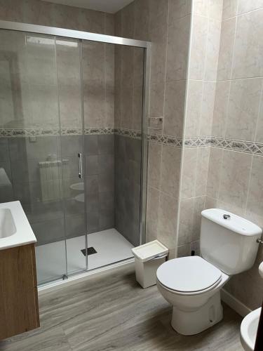 a bathroom with a shower and a toilet and a sink at Hostal La Balsá in La Alberca