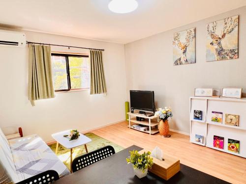 a living room with a couch and a tv at Hana Home - New Cozy House with 4 bedrooms - 10min from Umeda in Osaka