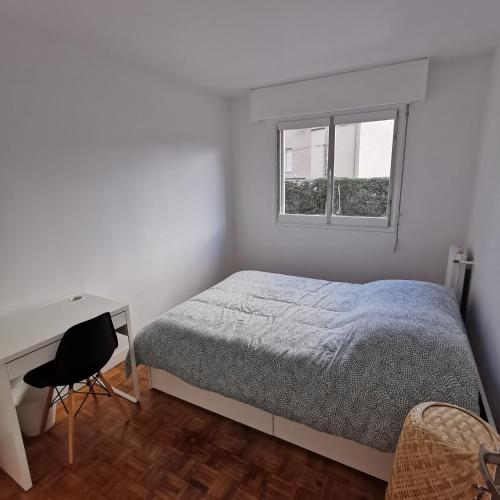 une chambre avec un lit, un bureau et une fenêtre dans l'établissement Chambre confort Saint Marceau, à Orléans