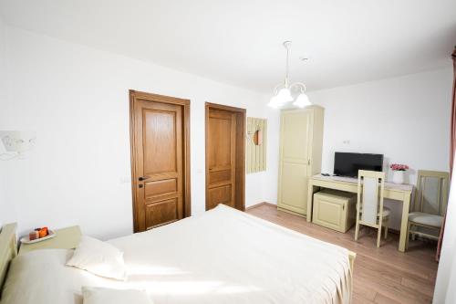 a bedroom with a bed and a desk with a television at Casa Andra in Siret