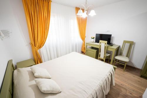 a bedroom with a bed and a desk with a computer at Casa Andra in Siret