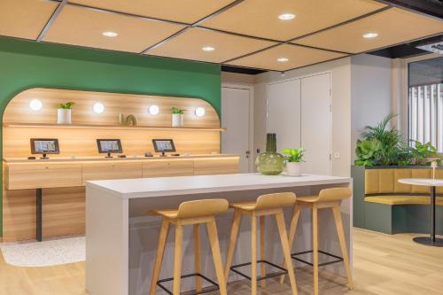a kitchen with a counter and stools in a room at Maxhotel Amsterdam Airport Schiphol in Hoofddorp