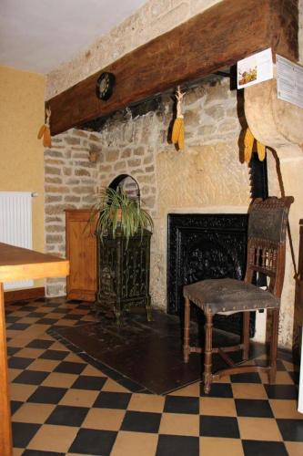 a living room with a fireplace and a chair at Chez leontine in Puilly-et-Charbeaux