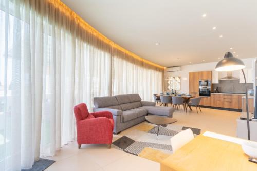 a living room with a couch and a red chair at Large apartment with pool in Is-Swieqi