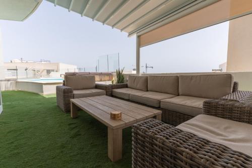 a patio with couches and a table on a roof at Large apartment with pool in Is-Swieqi