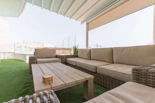 a patio with a couch and a table on a roof at Large apartment with pool in Is-Swieqi