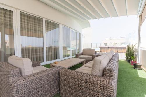 a patio with two wicker chairs and a table at Large apartment with pool in Is-Swieqi