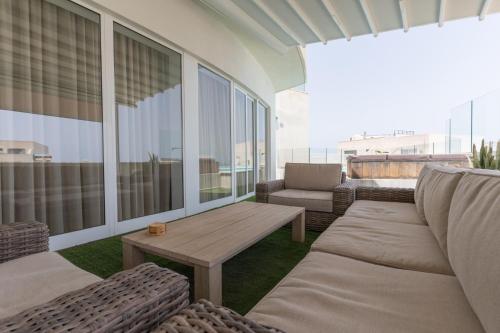 a patio with couches and a table on a balcony at Large apartment with pool in Is-Swieqi