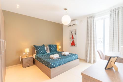 a bedroom with a bed with blue pillows at Large apartment with pool in Is-Swieqi