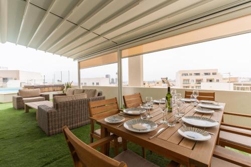 a dining room with a table with wine glasses at Large apartment with pool in Is-Swieqi