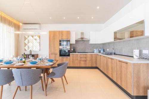 a large kitchen with a wooden table and chairs at Large apartment with pool in Is-Swieqi