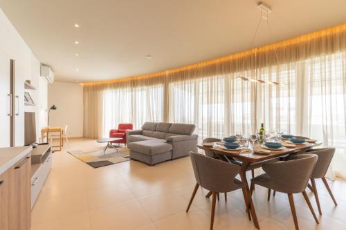 a living room with a table and a couch at Large apartment with pool in Is-Swieqi