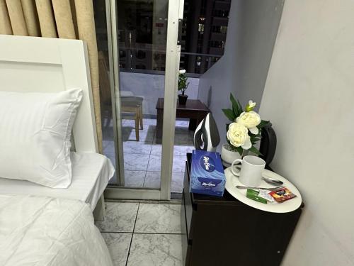 a bed and a table with a plate of flowers on it at Amazing Sea View Stay Abu Dhabi in Abu Dhabi