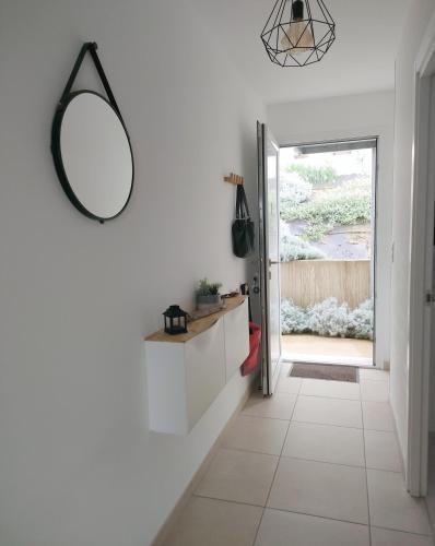 un couloir avec des murs blancs et un miroir sur le mur dans l'établissement Résidence Marina Di Bravone, à Linguizzetta