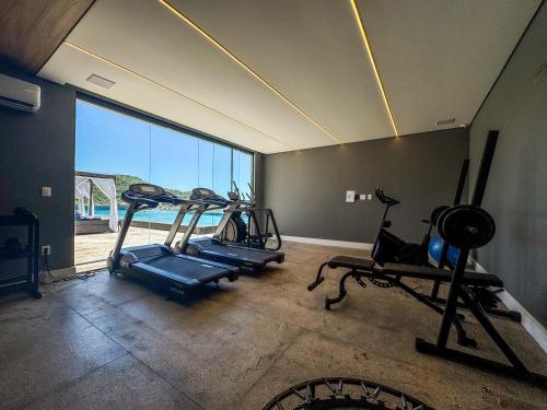 a gym with two exercise bikes and a large window at Blue Sea Hotel in Itapema
