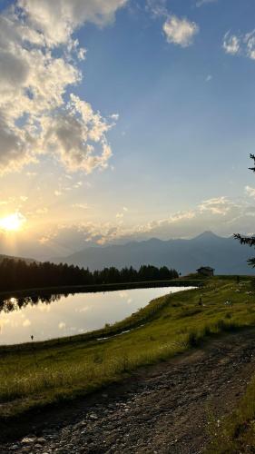 a large body of water with the sun in the sky at Alpine Dream House - Chalet in Gressan