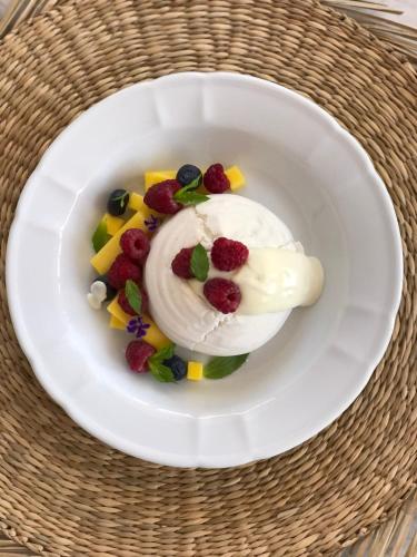 a white plate with a dessert with berries and whipped cream at Hotel Boutique Gualamba in General Pinedo