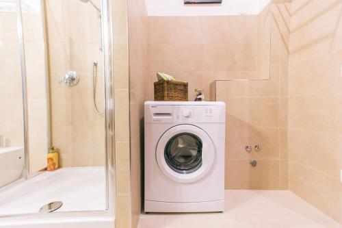 a washing machine in a bathroom with a shower at San Nicolò 3 in Verona
