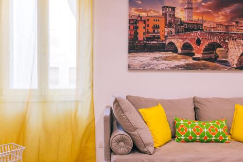 a couch with yellow pillows in a living room at San Nicolò 3 in Verona