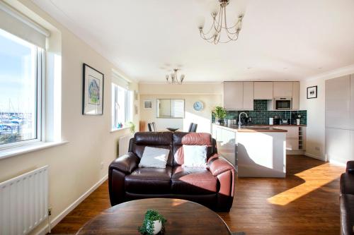a living room with a leather chair and a table at 2BR Apartment with Balcony on Brighton Marina in Brighton & Hove
