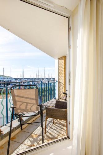 a balcony with a chair and a view of the water at 2BR Apartment with Balcony on Brighton Marina in Brighton & Hove
