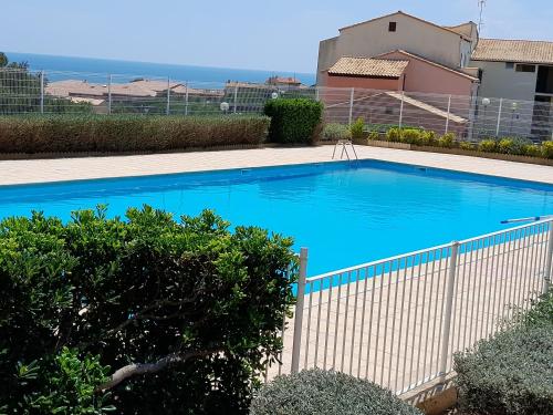 une grande piscine bleue à côté d'une clôture dans l'établissement Appartement Saint Pierre la Mer 4 personnes, vue sur la mer, piscine, parking, tennis N366, à Saint Pierre La Mer