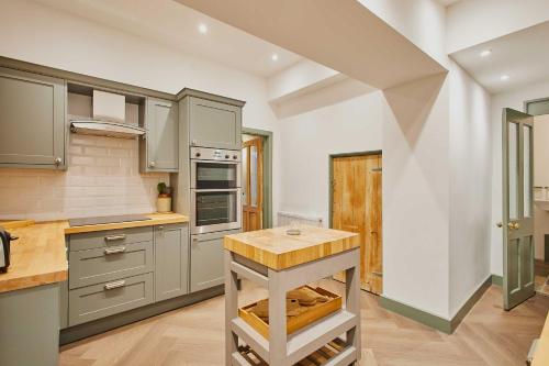 a kitchen with gray cabinets and a wooden island at Host & Stay - Temple Terrace in Richmond