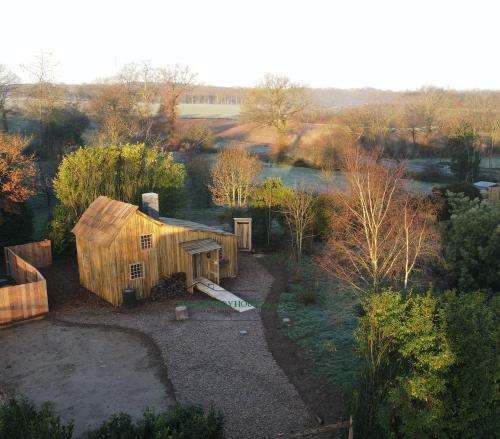 une vue de tête sur une petite maison en bois dans un champ dans l'établissement The country House 56, à Campénéac