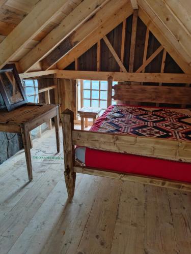 Cette chambre mansardée comprend un lit et une table. dans l'établissement The country House 56, à Campénéac