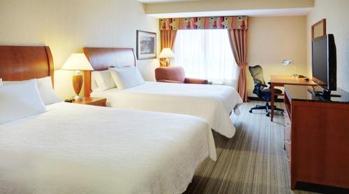 a hotel room with two beds and a desk at Hilton Garden Inn Toronto/Burlington in Burlington