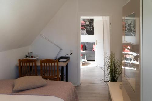 a bedroom with a bed and a table and a room at Zentrale ruhige 3-Zimmer-Wohnung in Kassel