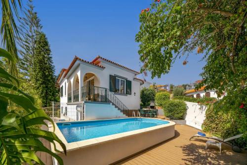 a villa with a swimming pool and a house at Villa Casa Amelia by Villa Plus in Caniço