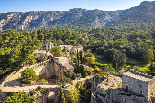 an old castle on a hill with mountains in the background at Villa Le Bastidon by Villa Plus in Les Taillades