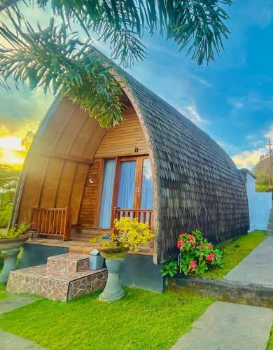 a round house with a round roof with flowers at Bali Cottages Lake View in Kintamani