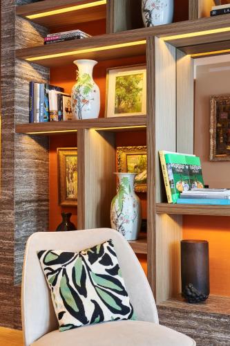 a room with a chair and shelves with vases at Maison Boissière BARNES Residences in Paris